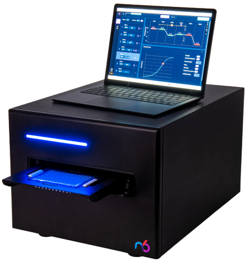 A black device with a blue light and a laptop displaying data on top.